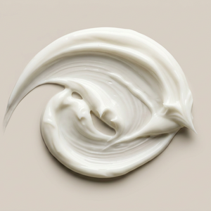 A swirl of thick, creamy white cosmetic cream or lotion on a solid beige background.